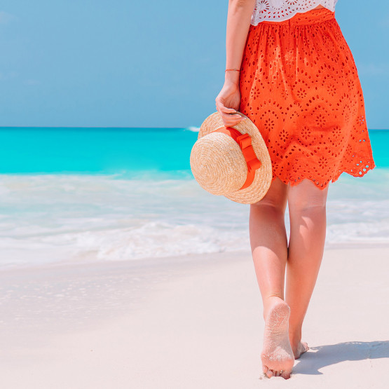 Kobieta na plaży bez butów, ilustracja do artykułu o espadrylach